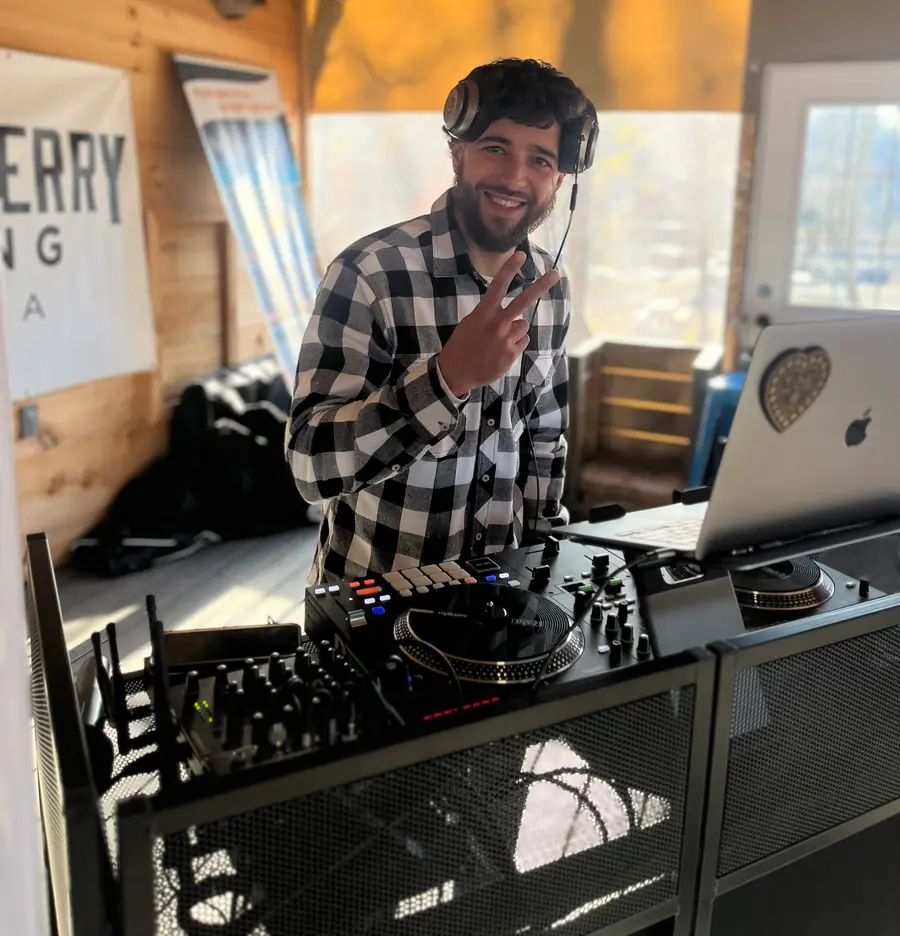 Jon smiling behind the DJ booth at an event